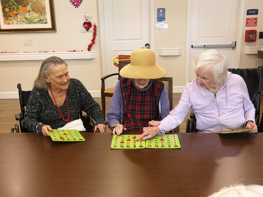 A group of three senior ladies playing bingo together.