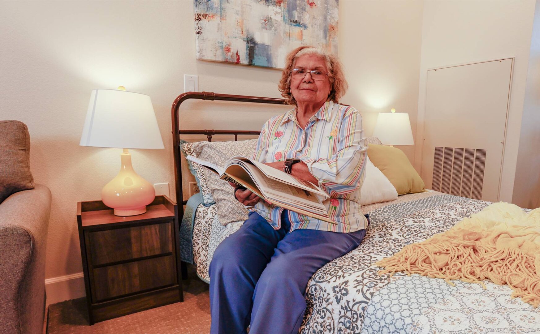 A woman sitting on top of a bed reading.