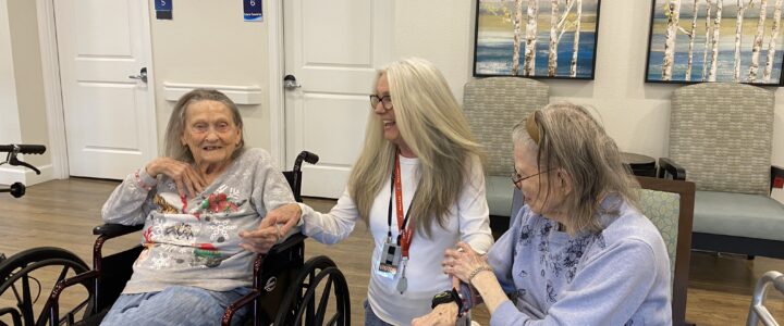 A caregiver and elderly women smiling together